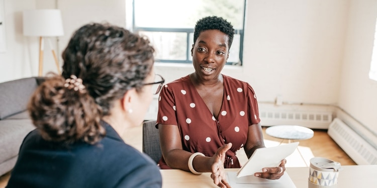 Two people discussing the differences between FHA and conventional home loans.