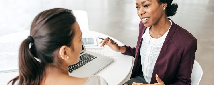 Two people sit at a table to talk about mutual funds.