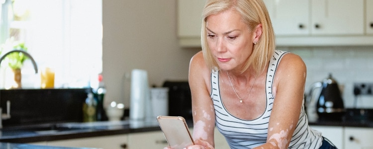 A woman uses her phone to check her options for closing a secured credit card.