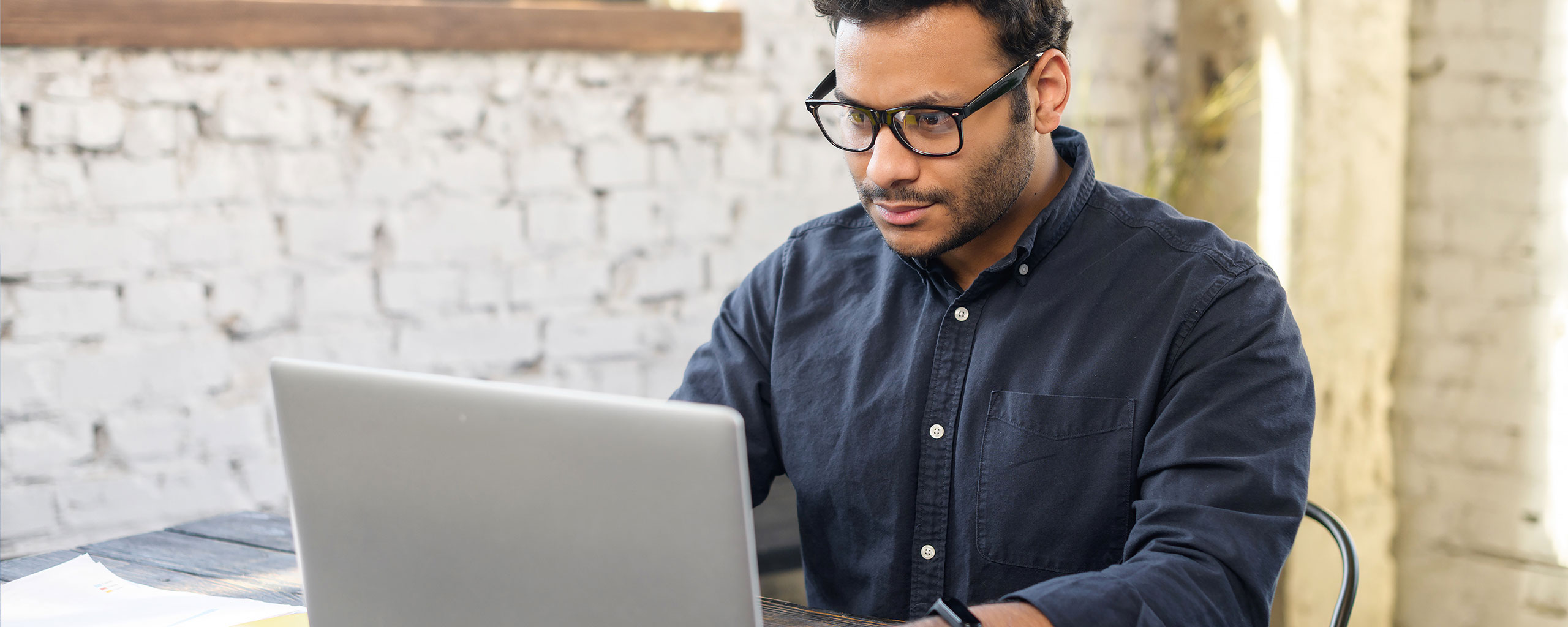 A person sits at a table reading about installment loans on their laptop.