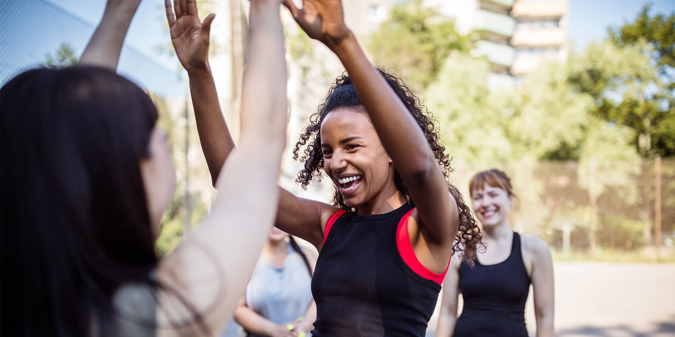 A person smiles and gives two high fives to someone in front of her.