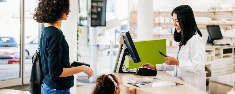 A parent and child at a pharmacy checkout.