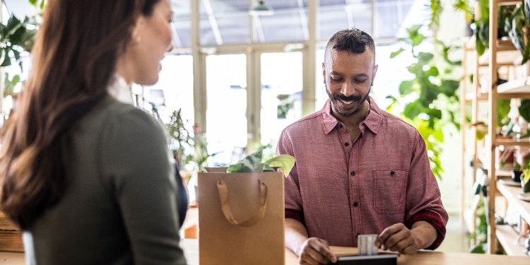 A person buying groceries with a credit card, using some of their card account’s available credit.