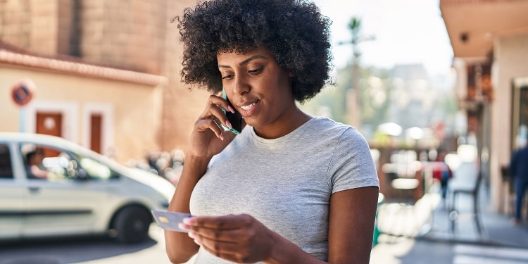 A person looks at their credit card and calls to see why it’s suspended.