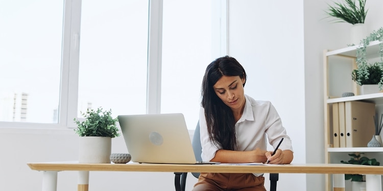 A person working at their desk with their laptop open.