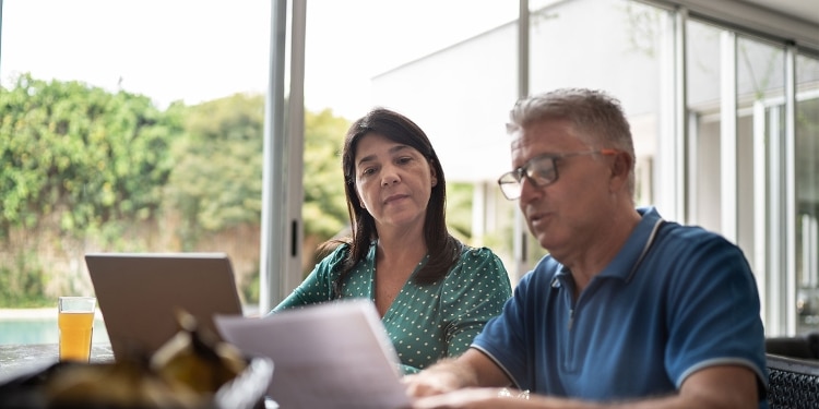A couple using a laptop at home to explore options for repairing their credit.