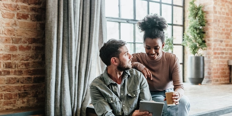 Two people look at credit card options on a tablet.
