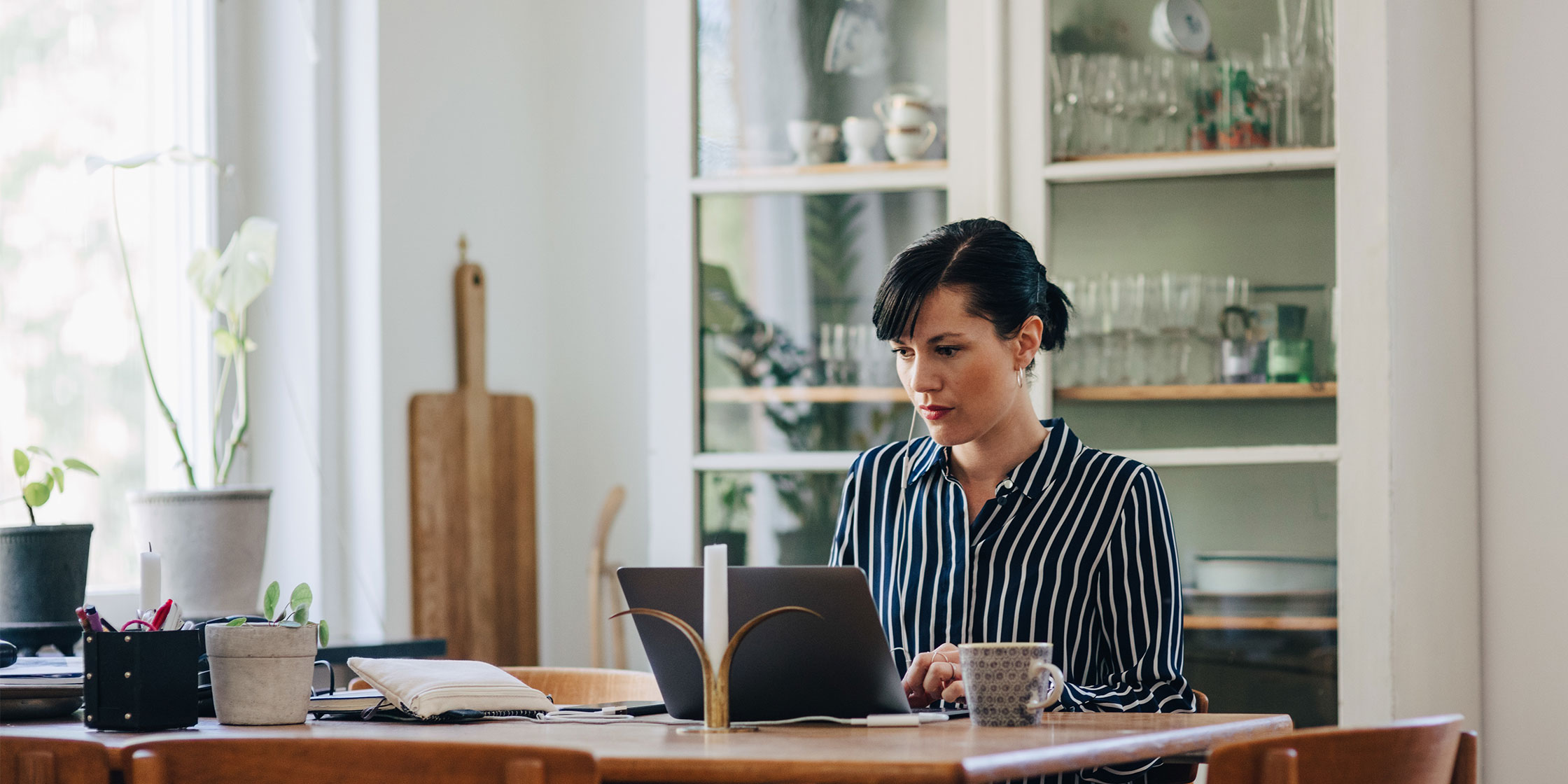 A person sits at a desk and looks at information on a laptop about a personal loan.