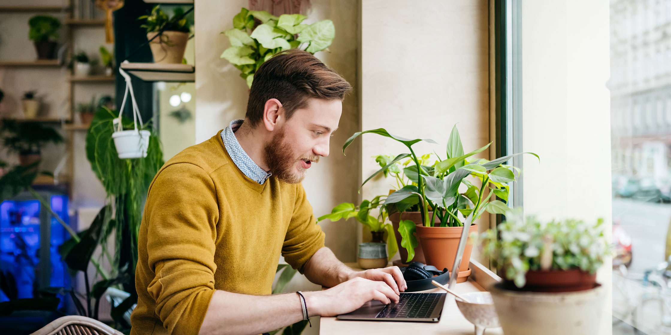 A person sitting at a table reads about a credit-builder loan on their laptop.