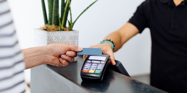 A person uses their credit card to make a purchase at a retail store.