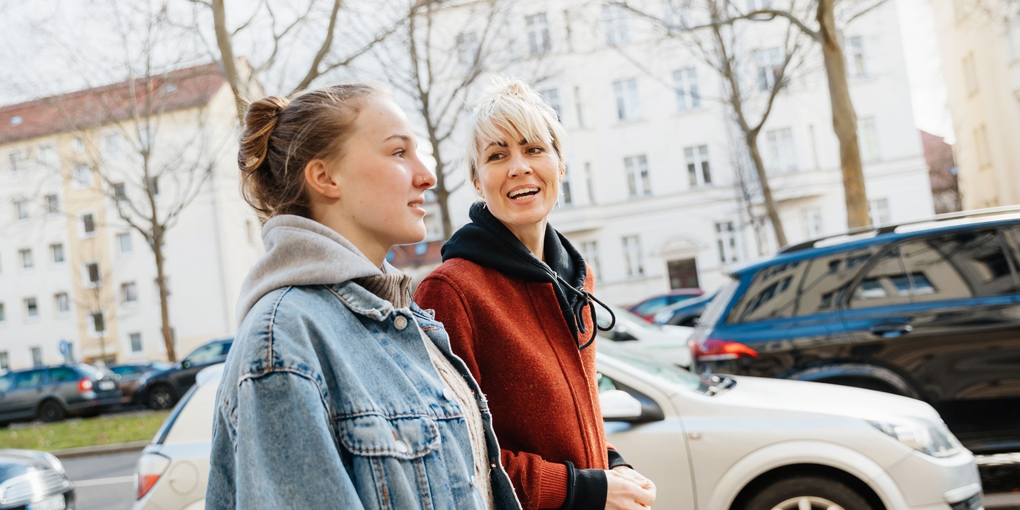 A photo of a parent and their teenager taking a walk and talking about building credit.