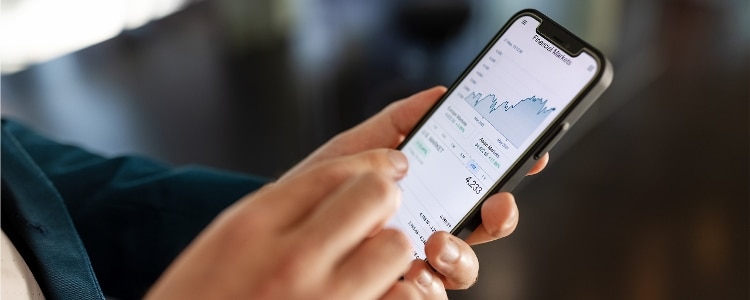 A person uses their phone to check the liquidity of their investments.