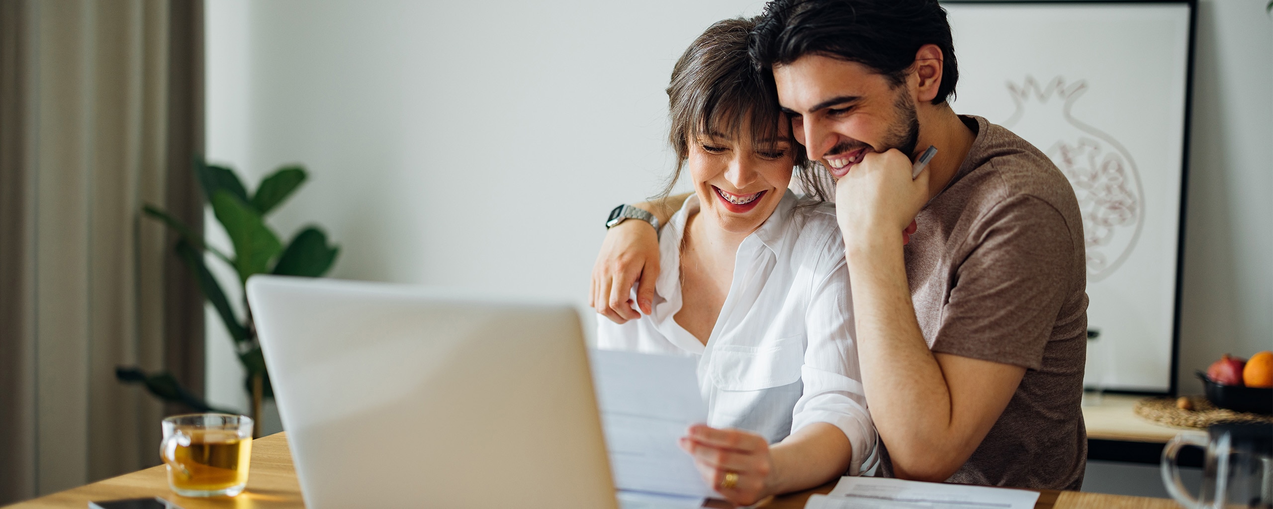 A couple sits at their desk and uses their HSA funds to pay a medical bill.