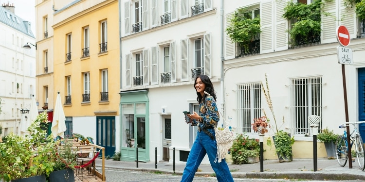 A young person crosses a street in Paris.