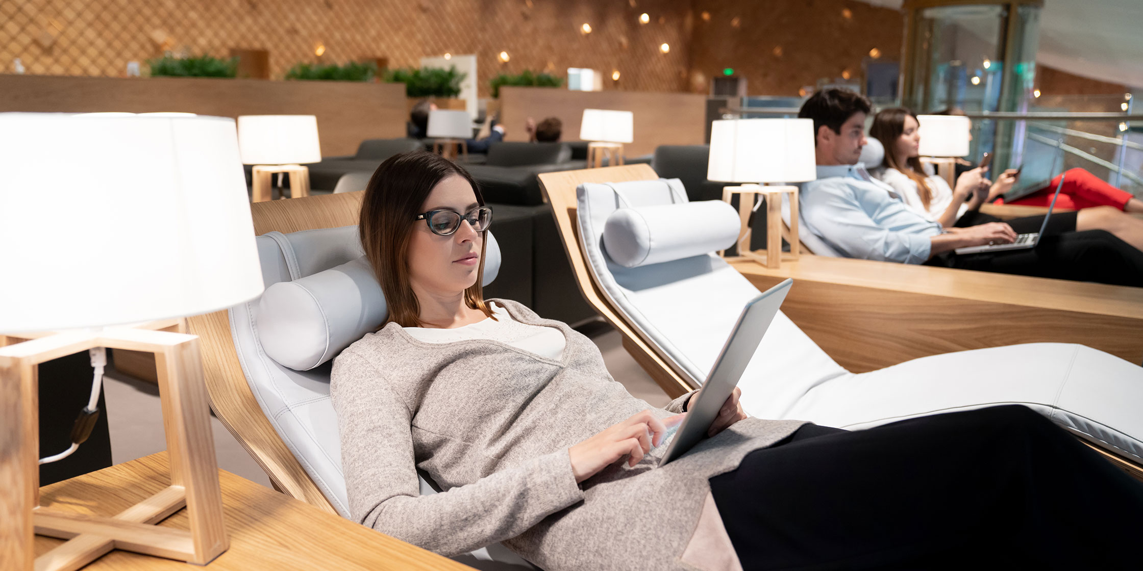 A person reclines and relaxes as they upgrade to a first-class seat before a flight.