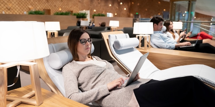 A person reclines and relaxes as they upgrade to a first-class seat before a flight.