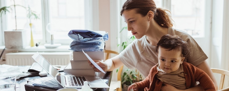 A parent sits with their child at a desk to work on their zero-based budget.