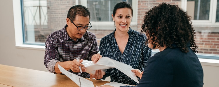 A couple reviews the terms of their new loan with a creditor.