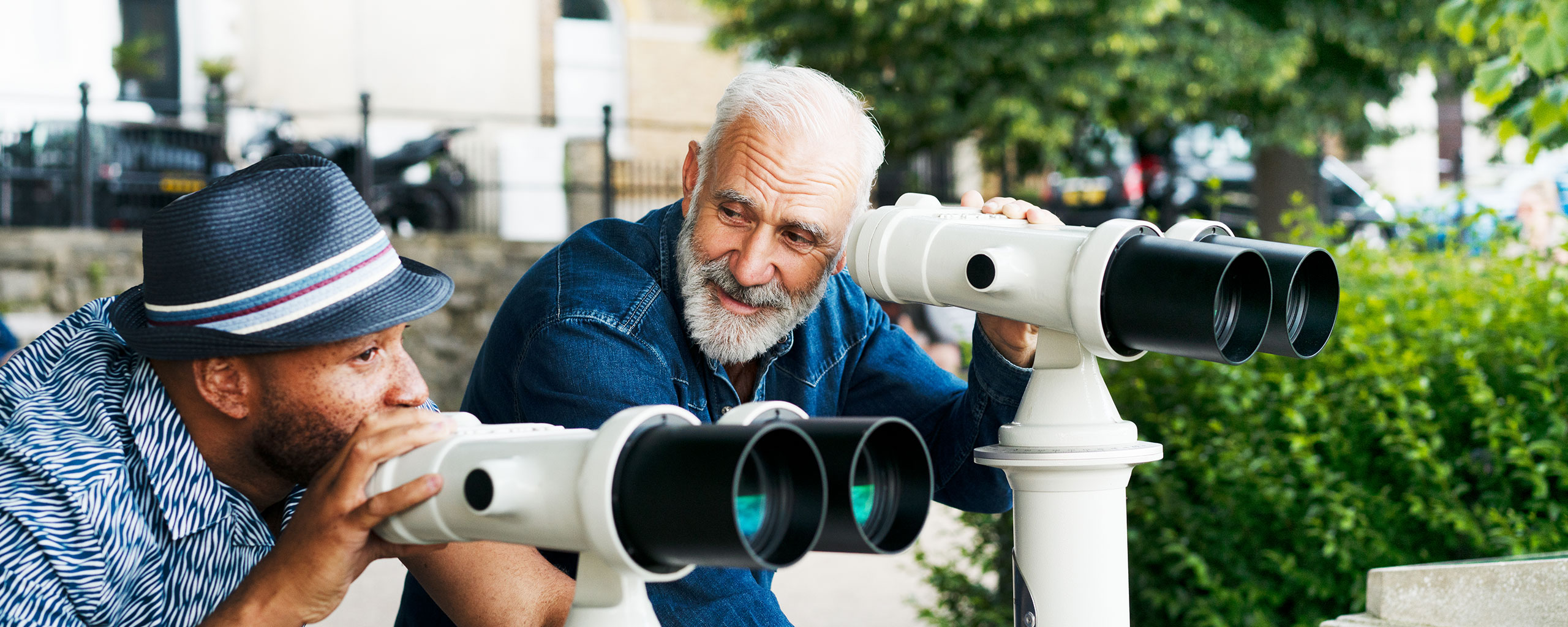 Two people using binoculars to look at a view.