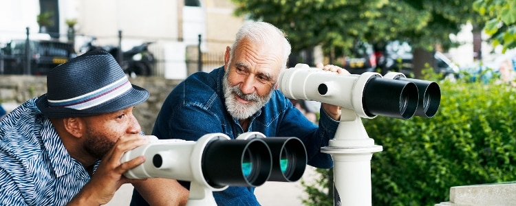 Two people using binoculars to look at a view.