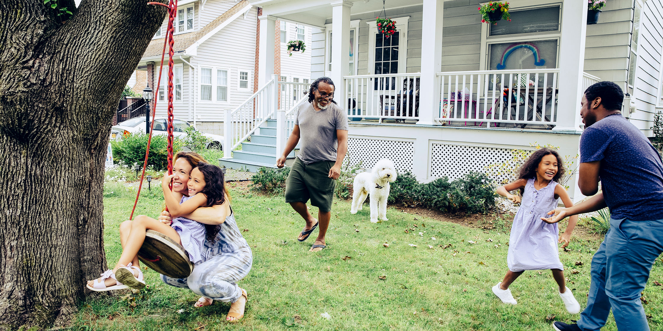 A photo of a family having fun together in the front yard of their home.