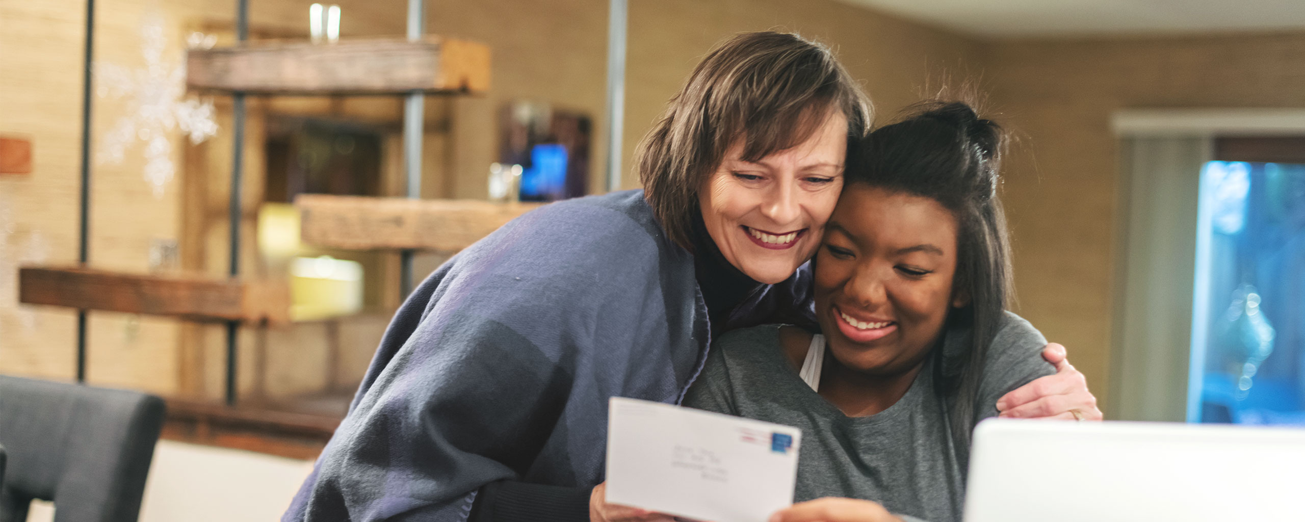 A photo of a smiling parent and child getting good news about a college scholarship offer.