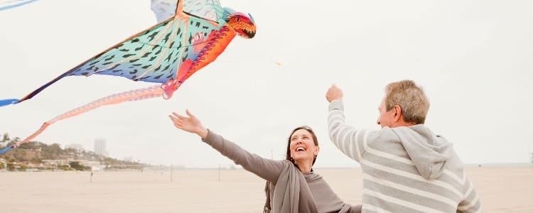 Two people flying a kite on the beach.