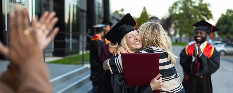 A college graduate hugs her mother after the graduation ceremony.