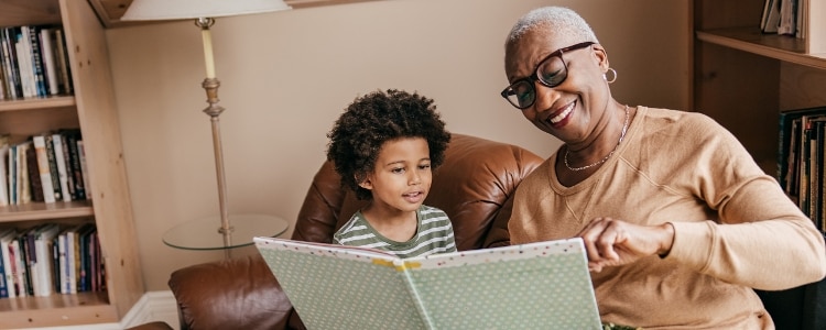 A person enjoys their retirement by reading to their grandchild.