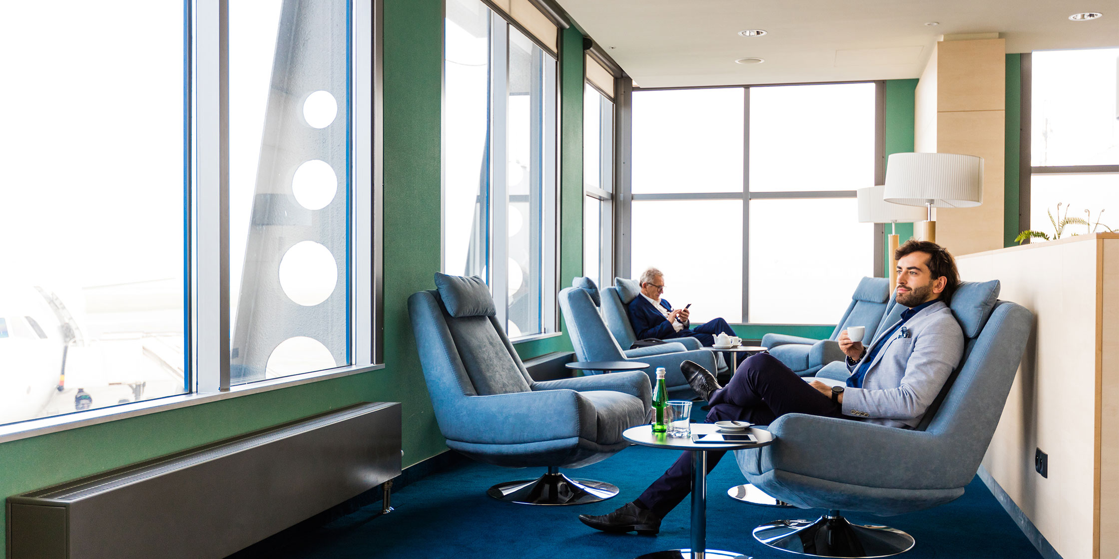 A Venture X cardholder using their complimentary Priority Pass membership relaxes in a Priority Pass airport lounge.