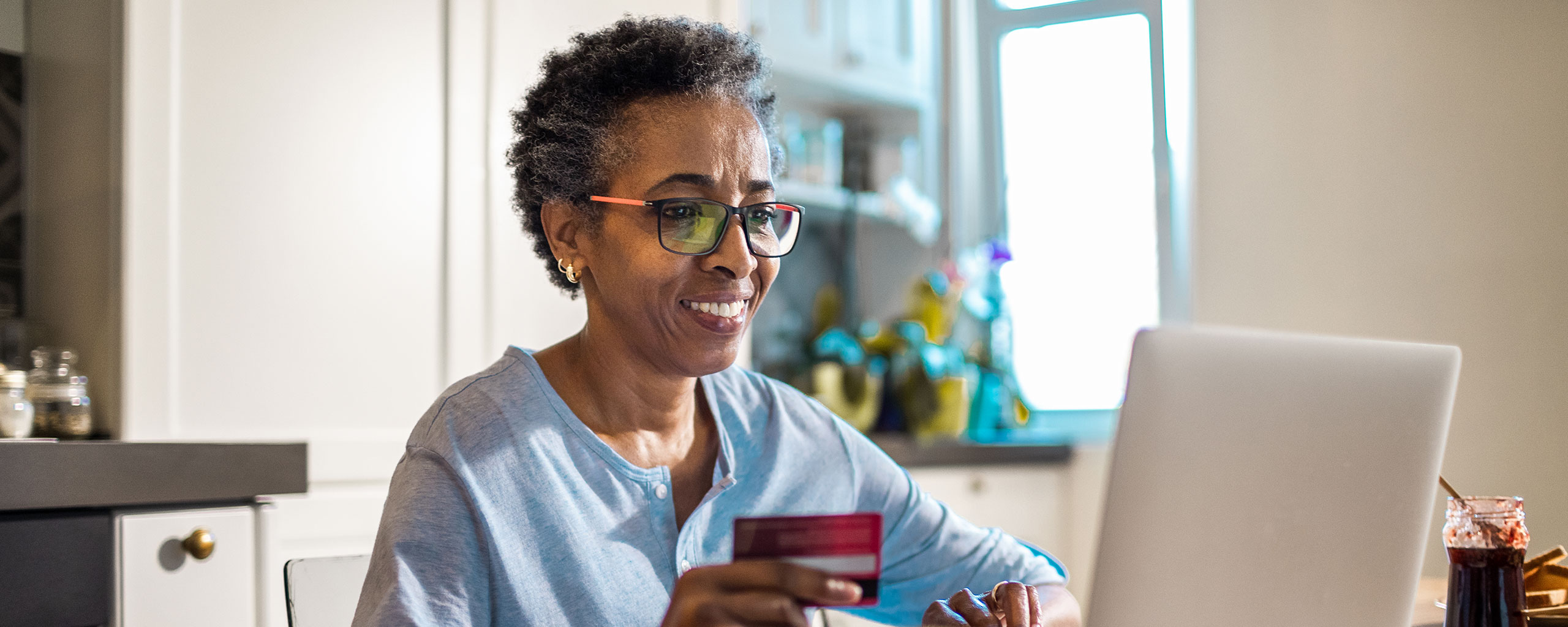 Person in glasses using their credit card to shop online.