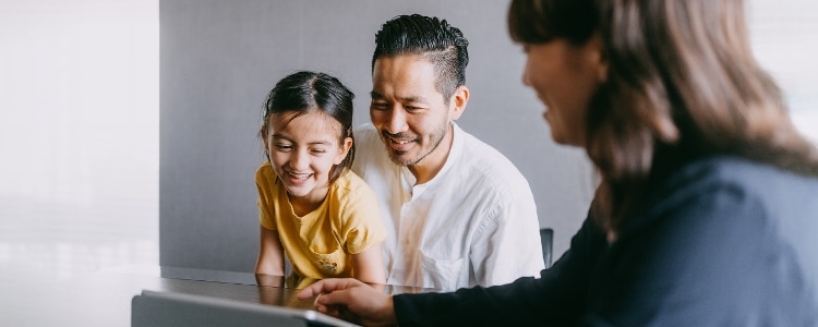 A parent and child having a meeting with an adviser.