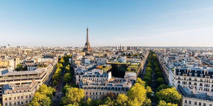 Aerial view of the rooftops of Paris, with the Eiffel Tower in the distance.