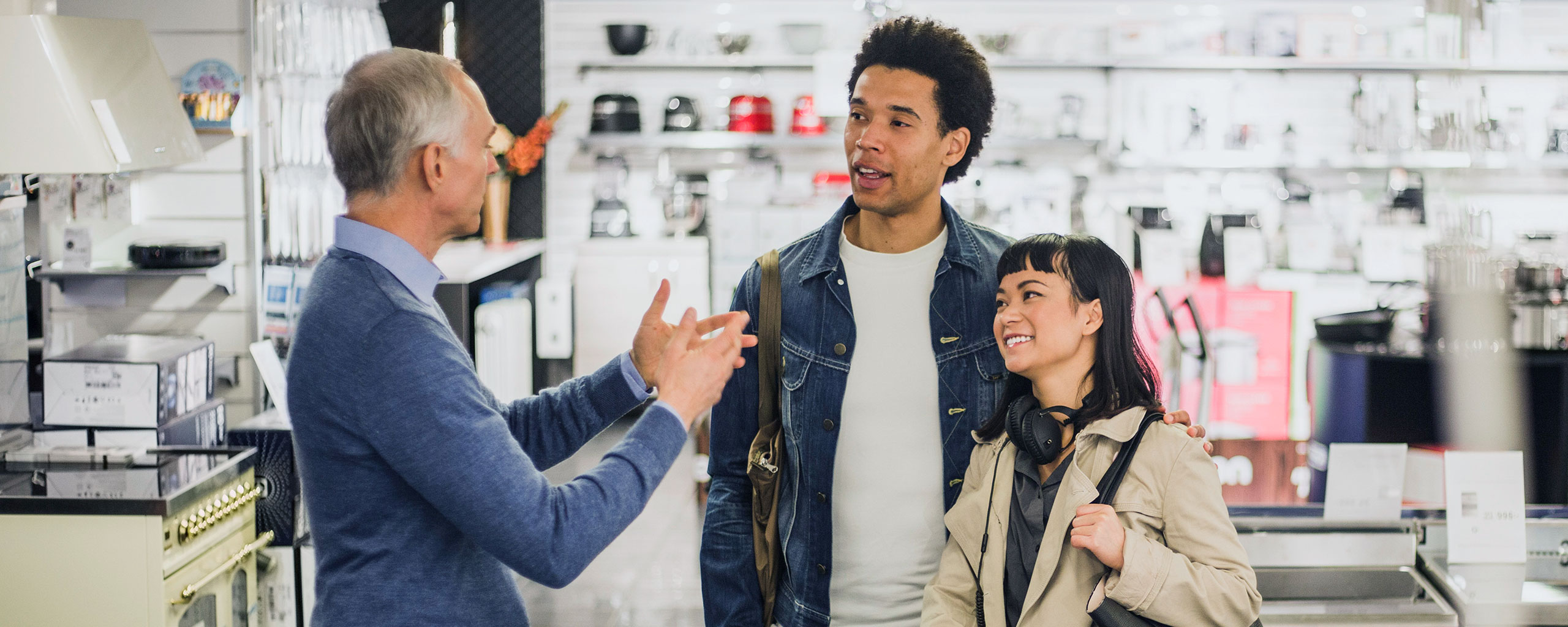 A person in a store talks to a couple.