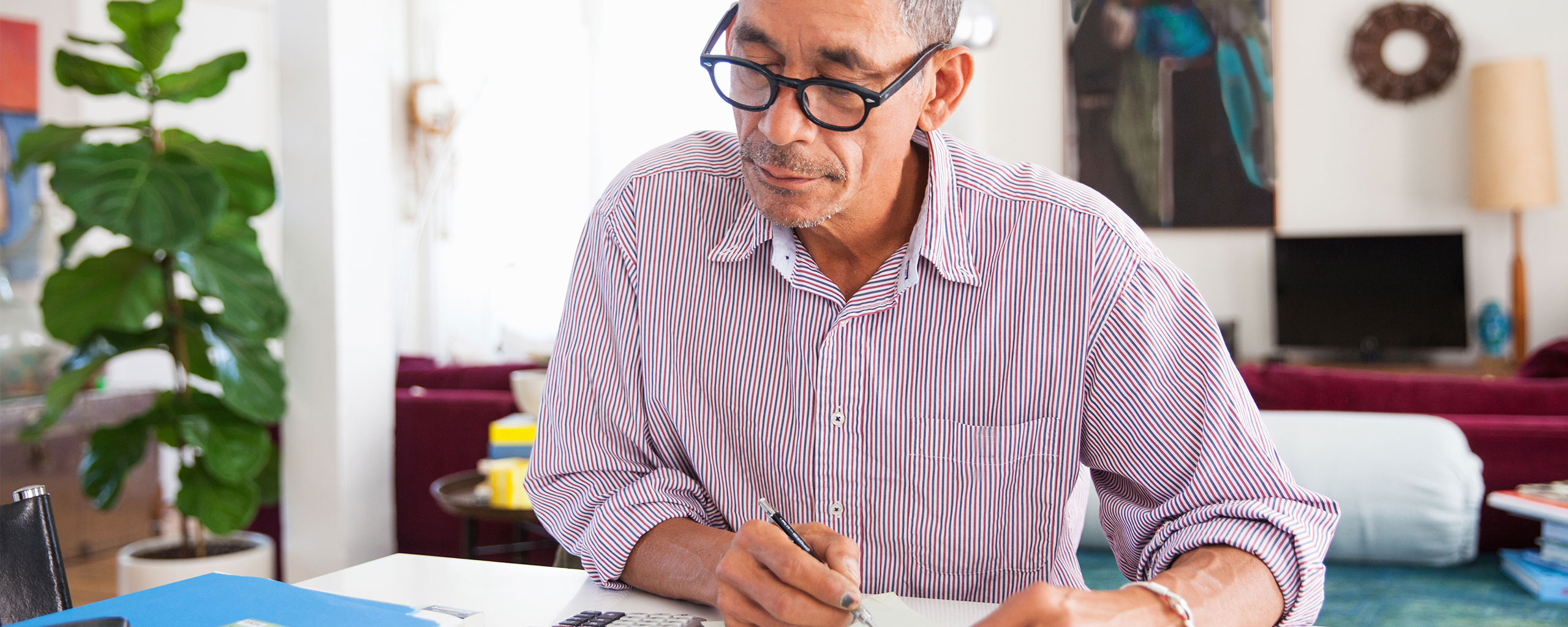 A person sits at a desk and calculates their accrued interest.