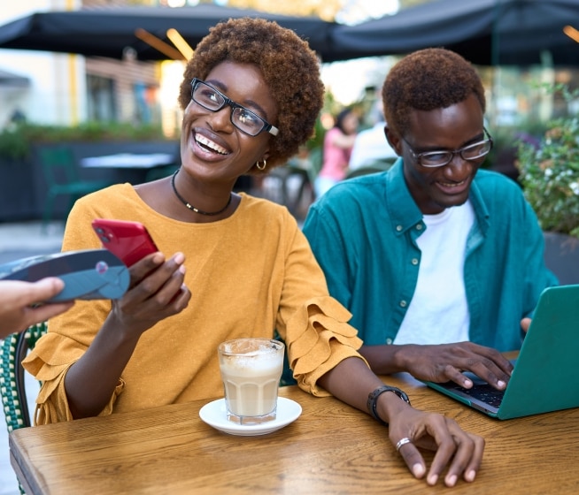 Two people using tap to pay at a cafe.