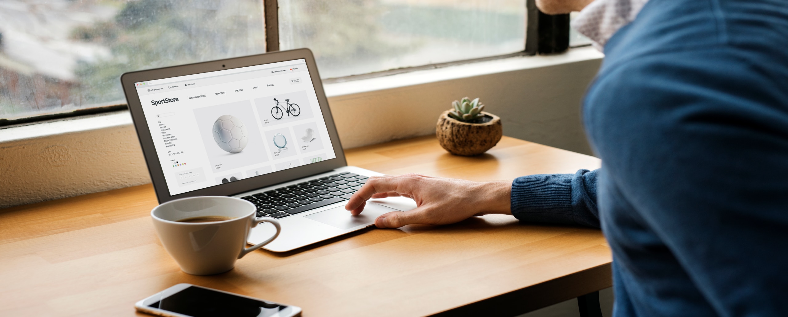 Person sitting at desk scrolling on their laptop.