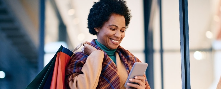 Person looking at smartphone while shopping.