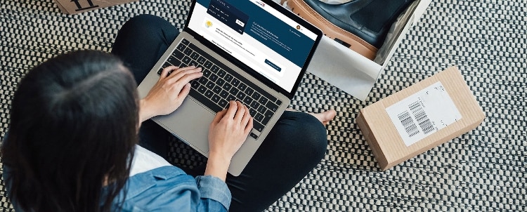 Person sitting on the floor with laptop open.