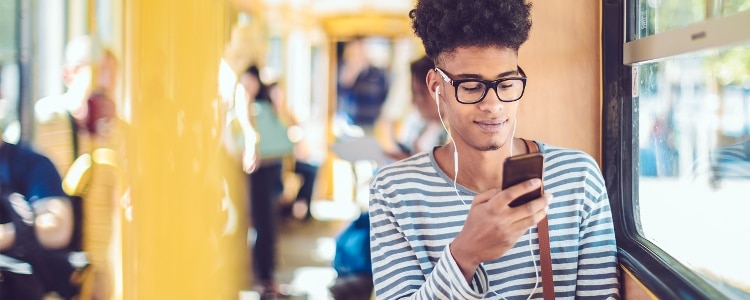 Person using a smartphone on public transit readers tips for mobile fraud prevention.