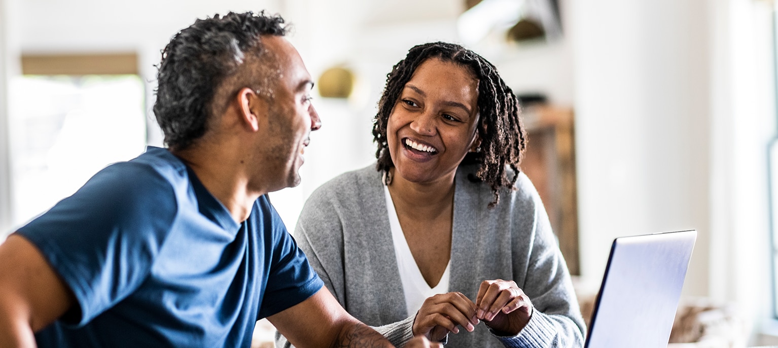Couple talking about their finances at the kitchen table