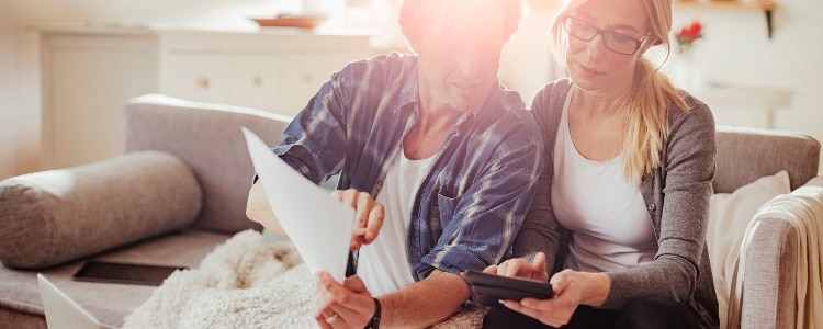 Two people on a coach review pension documents and plan for retirement.