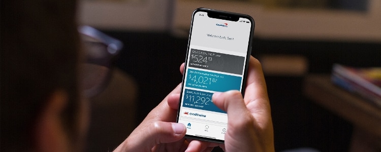 Man using a mobile phone to check his Capital One mobile app.
