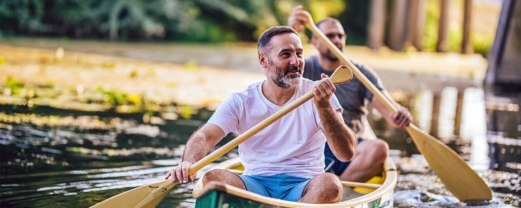 Two people in a canoe paddling down a creek.
