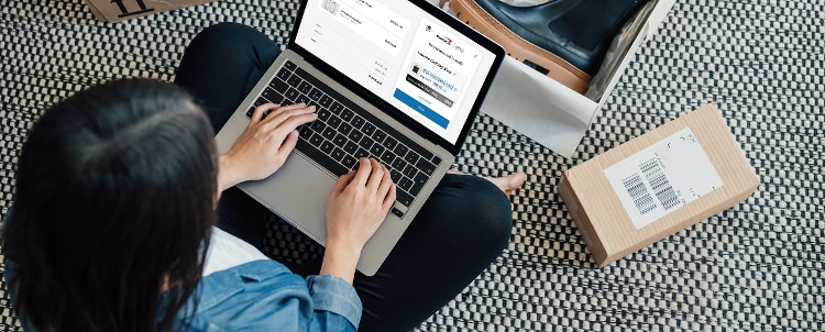Person sitting on the floor with laptop open.