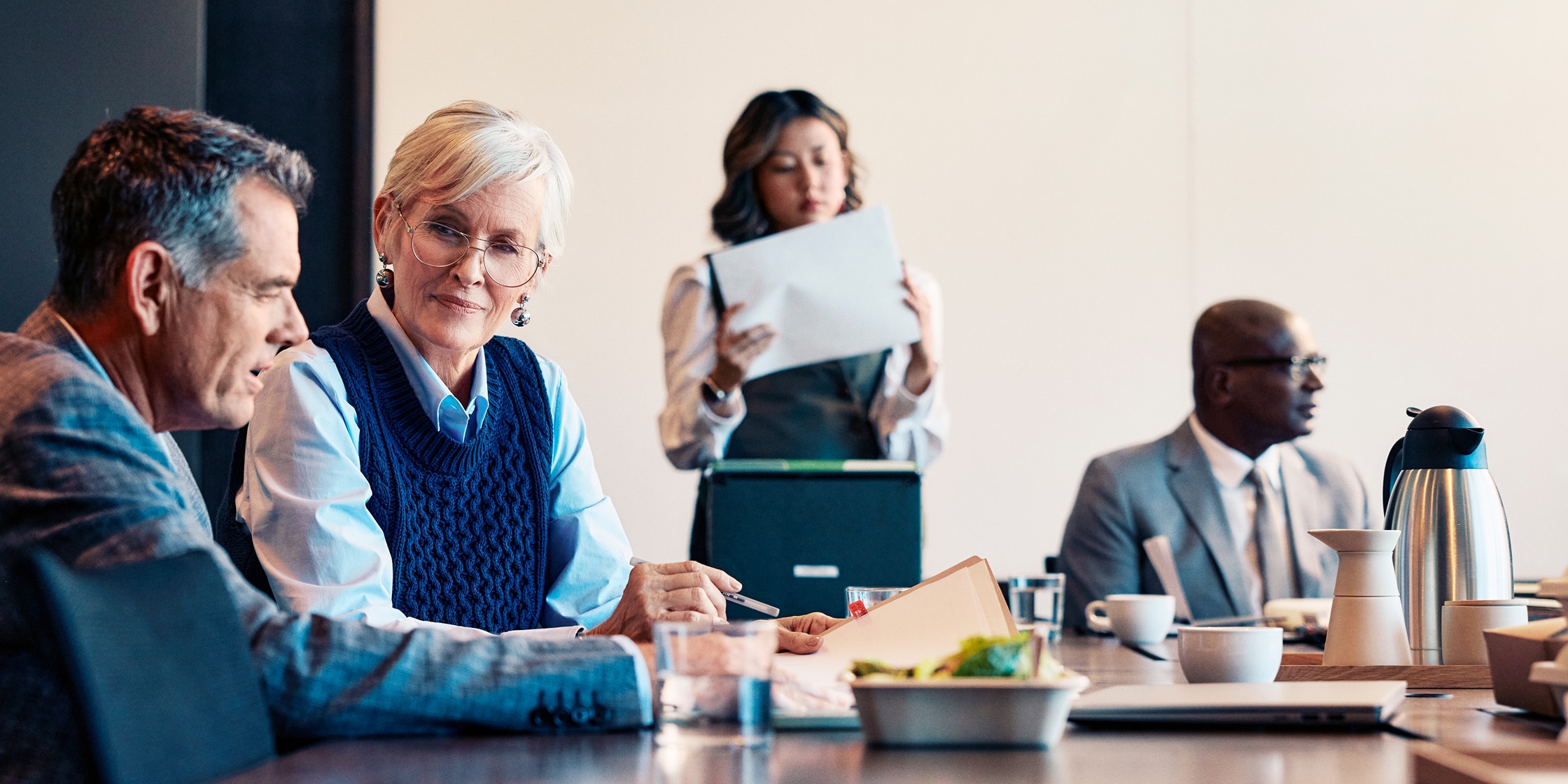 A group of people sit around an office conference table.