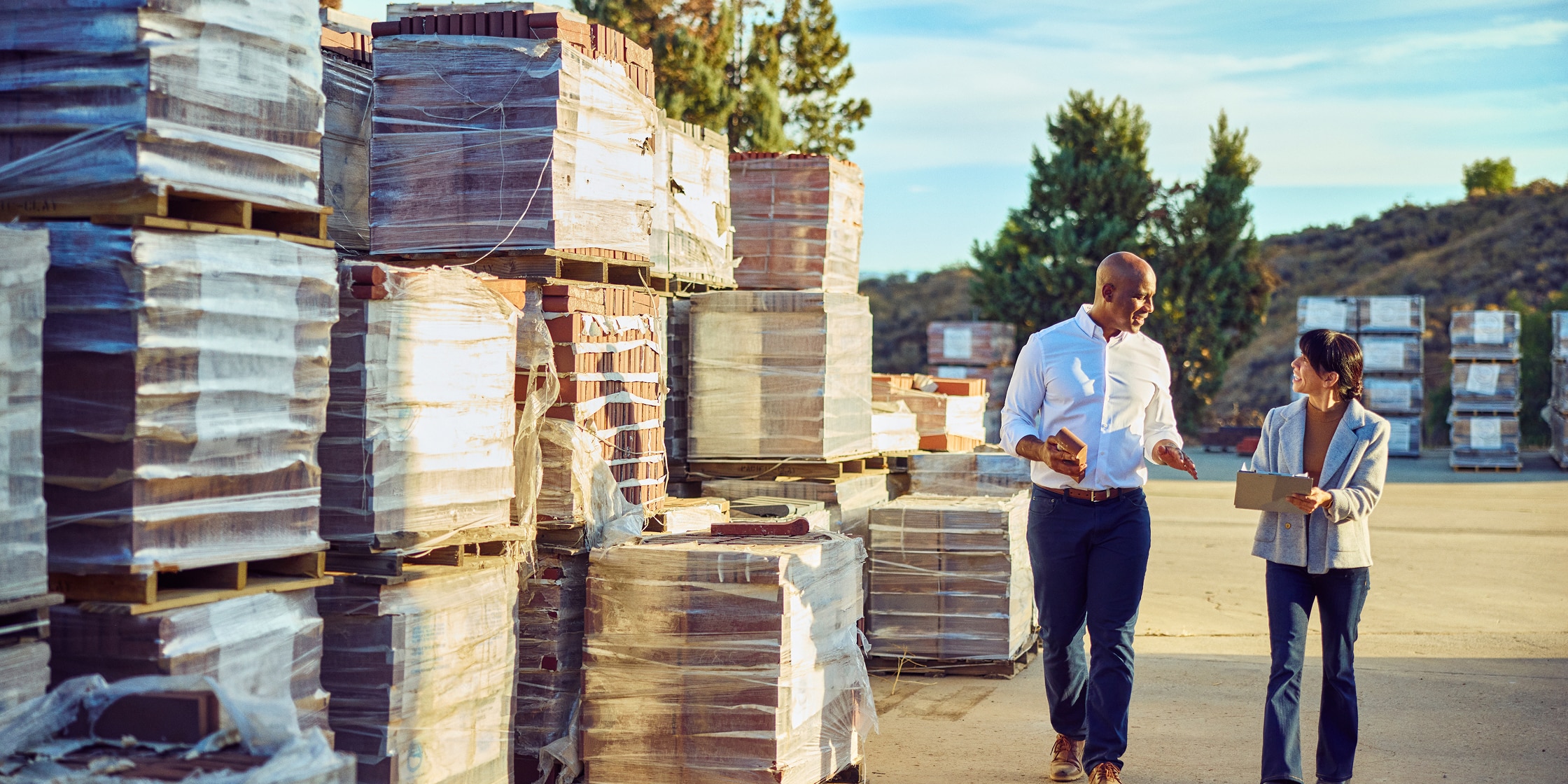 Two people walk through a jobsite together.