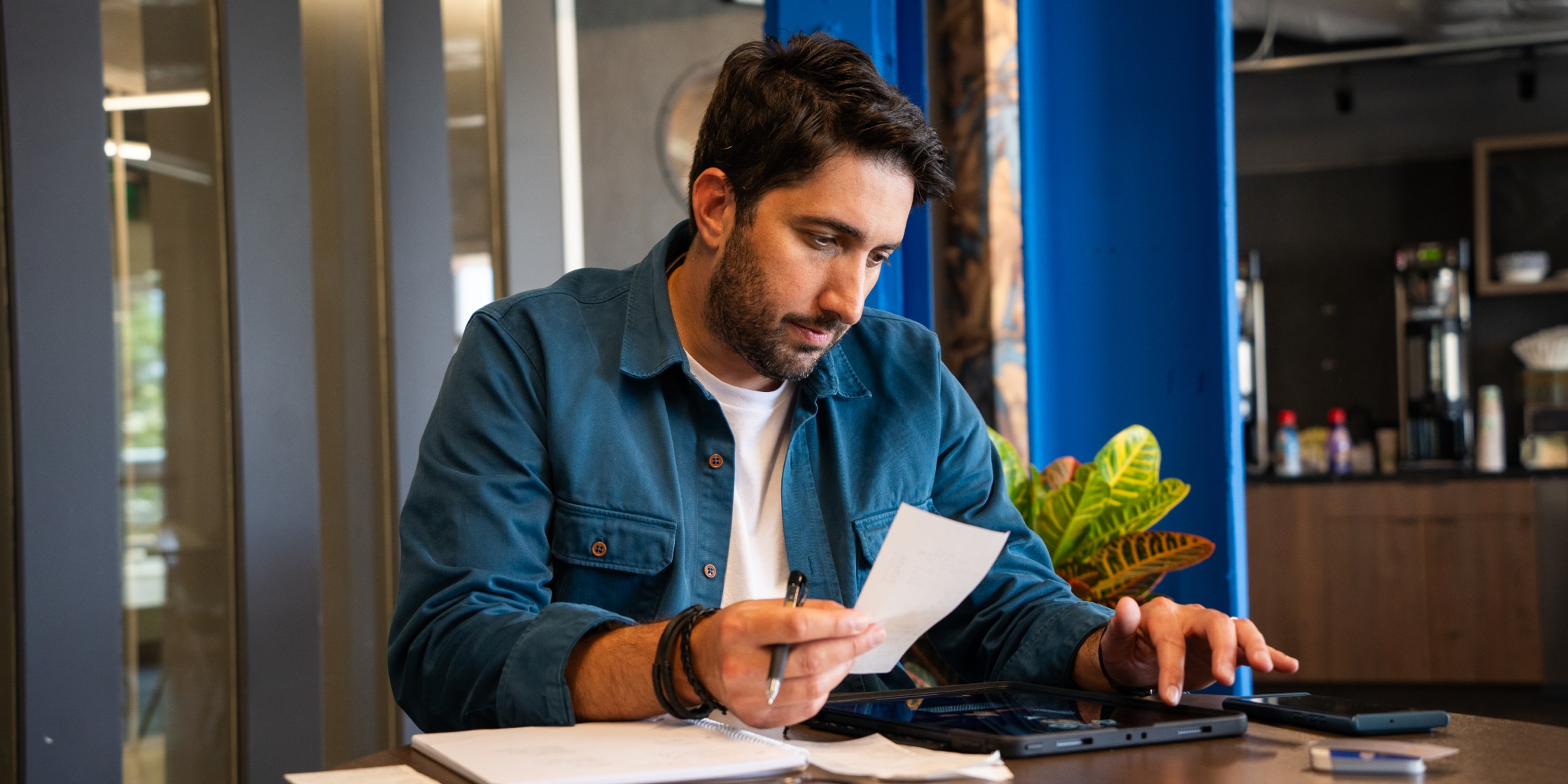 A middle-aged man going through his expenses, reviewing receipts for an expense reimbursement policy.