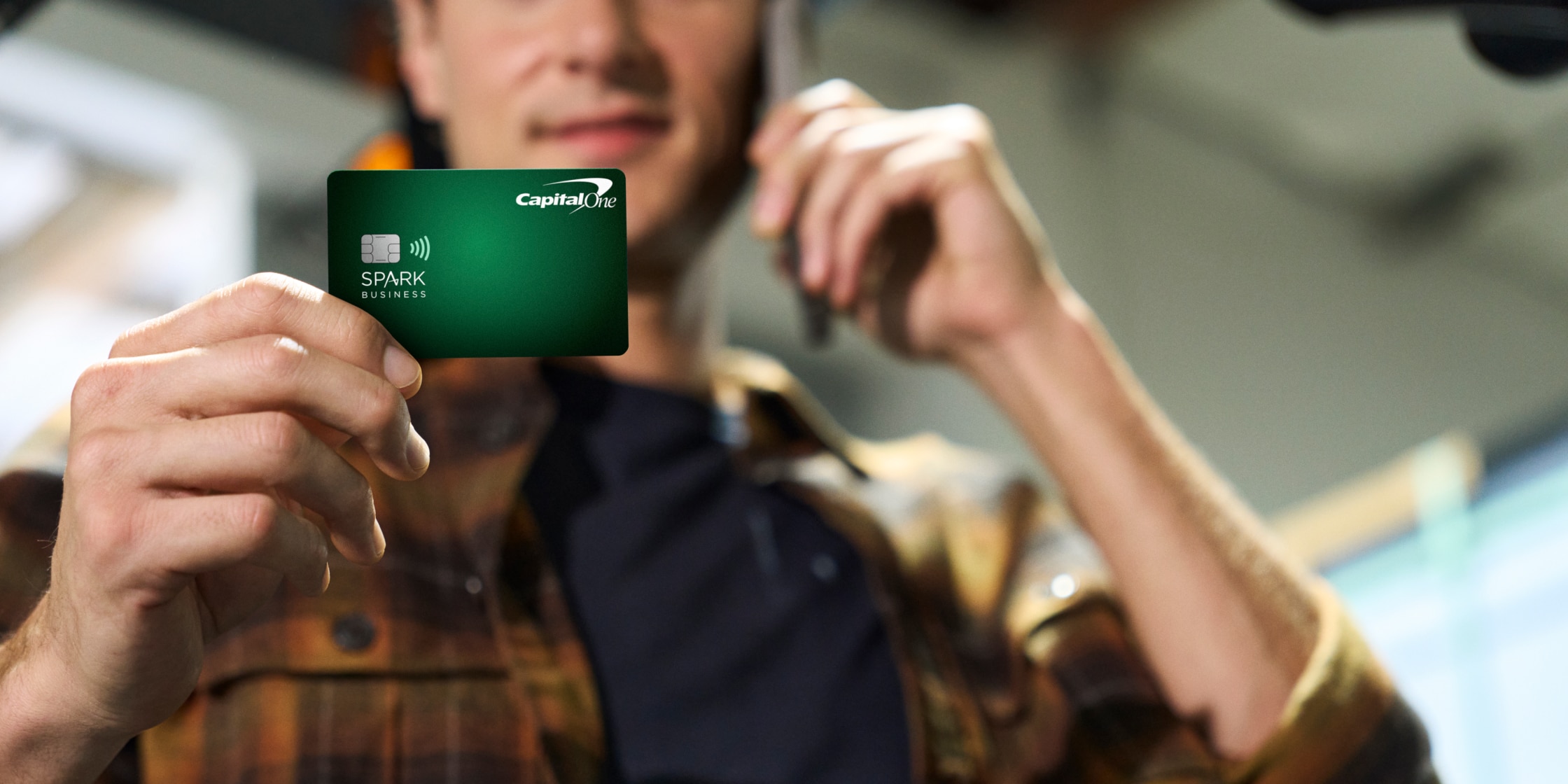Business owner holding a Capital One Business card