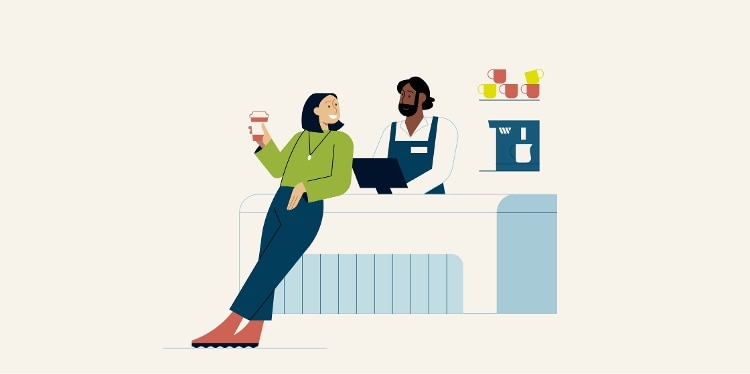 Customer holding a cup of coffee and leaning against the check-out counter chatting with the barista.